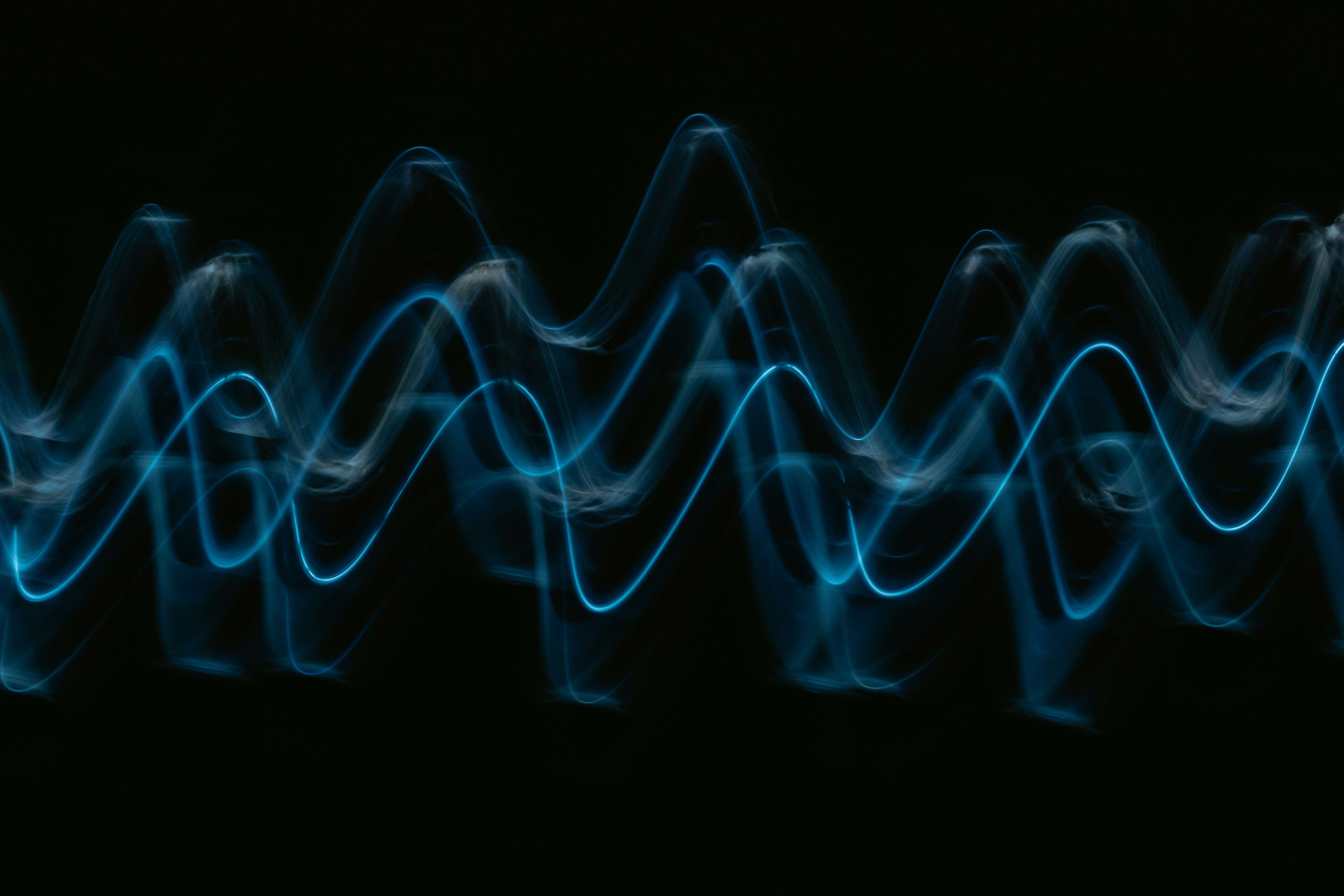 暗い背景に青い音の波形が浮かんでいる画像